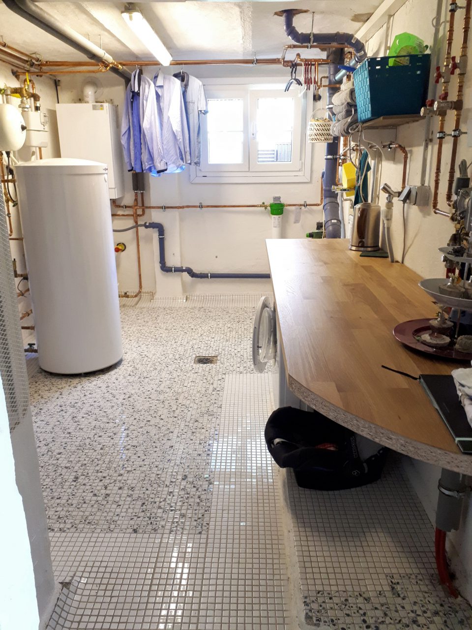 Die Waschküche im Kellergeschoss nach der Sanierung mit neuer Heizung und Fliesenboden.