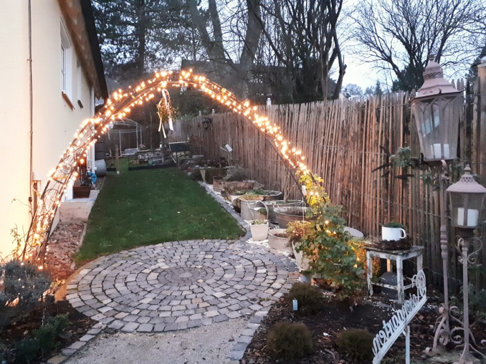 Die Lichterkette am Rosenbogen als Teil der Gartenbeleuchtung wird nur zur Adventszeit genutzt.